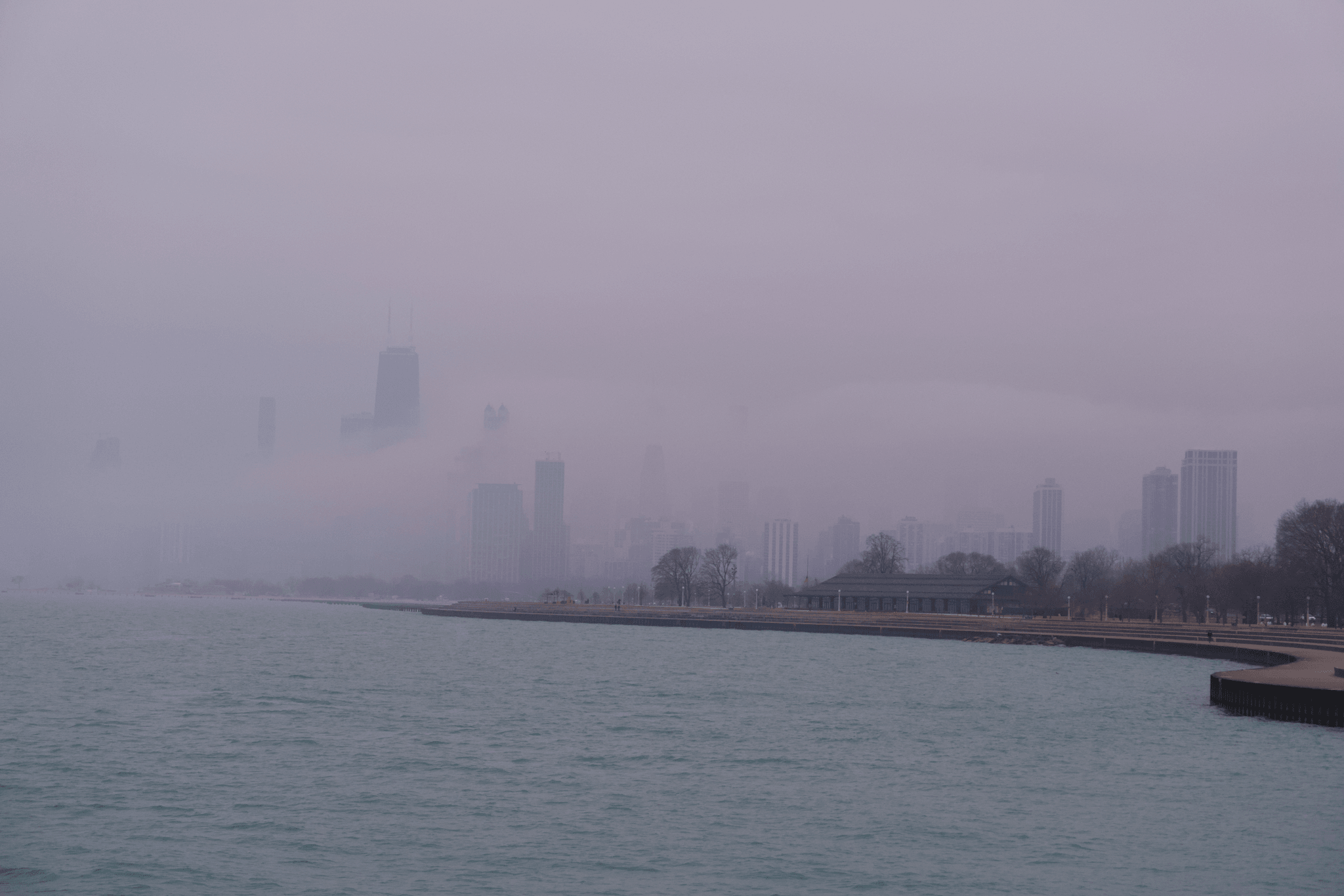 The Chicago skyline shrouded in fog, seen from a northern pier.