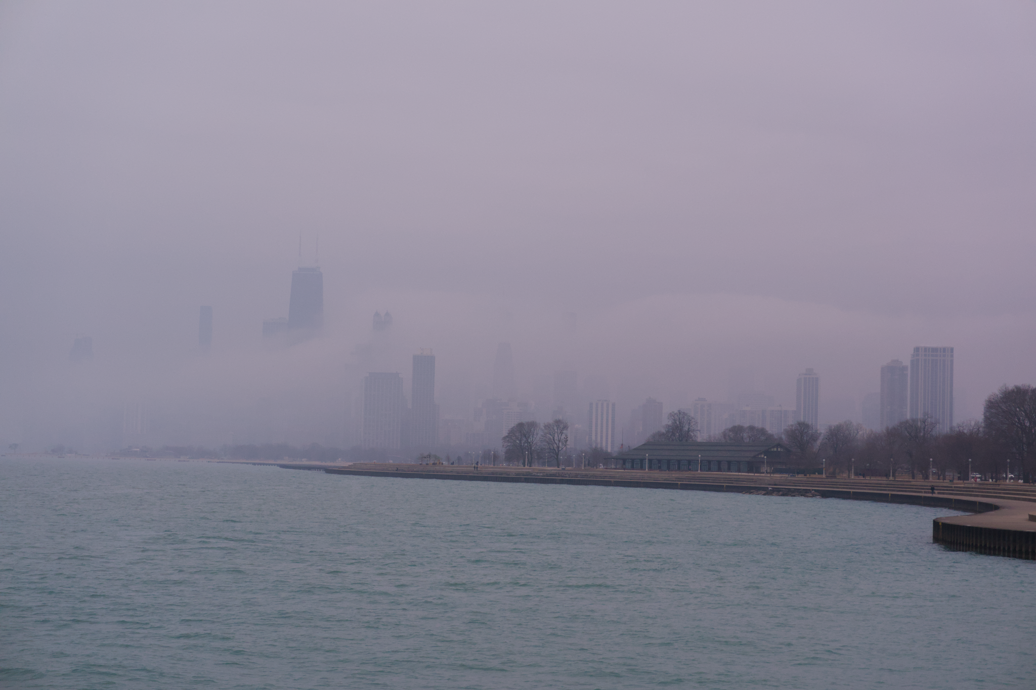 The Chicago skyline shrouded in fog, seen from a northern pier.