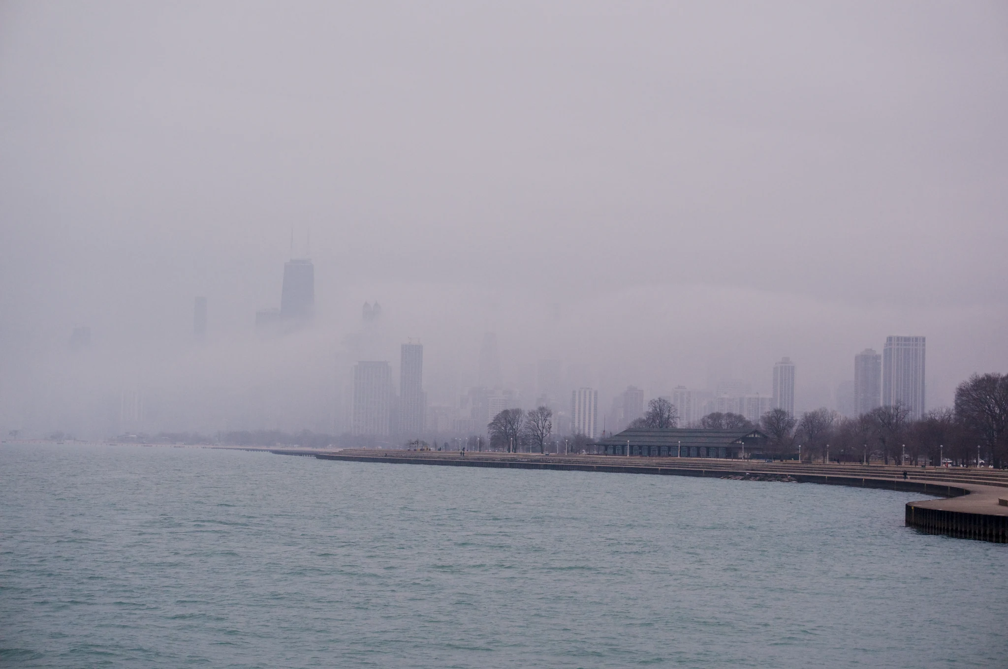 The Chicago skyline shrouded in fog, seen from a northern pier.